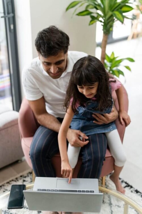 Father sitting with daughter and using laptop to explore CurioBuddy website for school age children at home. CurioBuddy provides a safe and secure platform for primary school to middle school students for curiosity and creativity along with collaborative learning through its community that reinforces classroom knowledge. Subscribe to children's magazines with CurioBuddy.